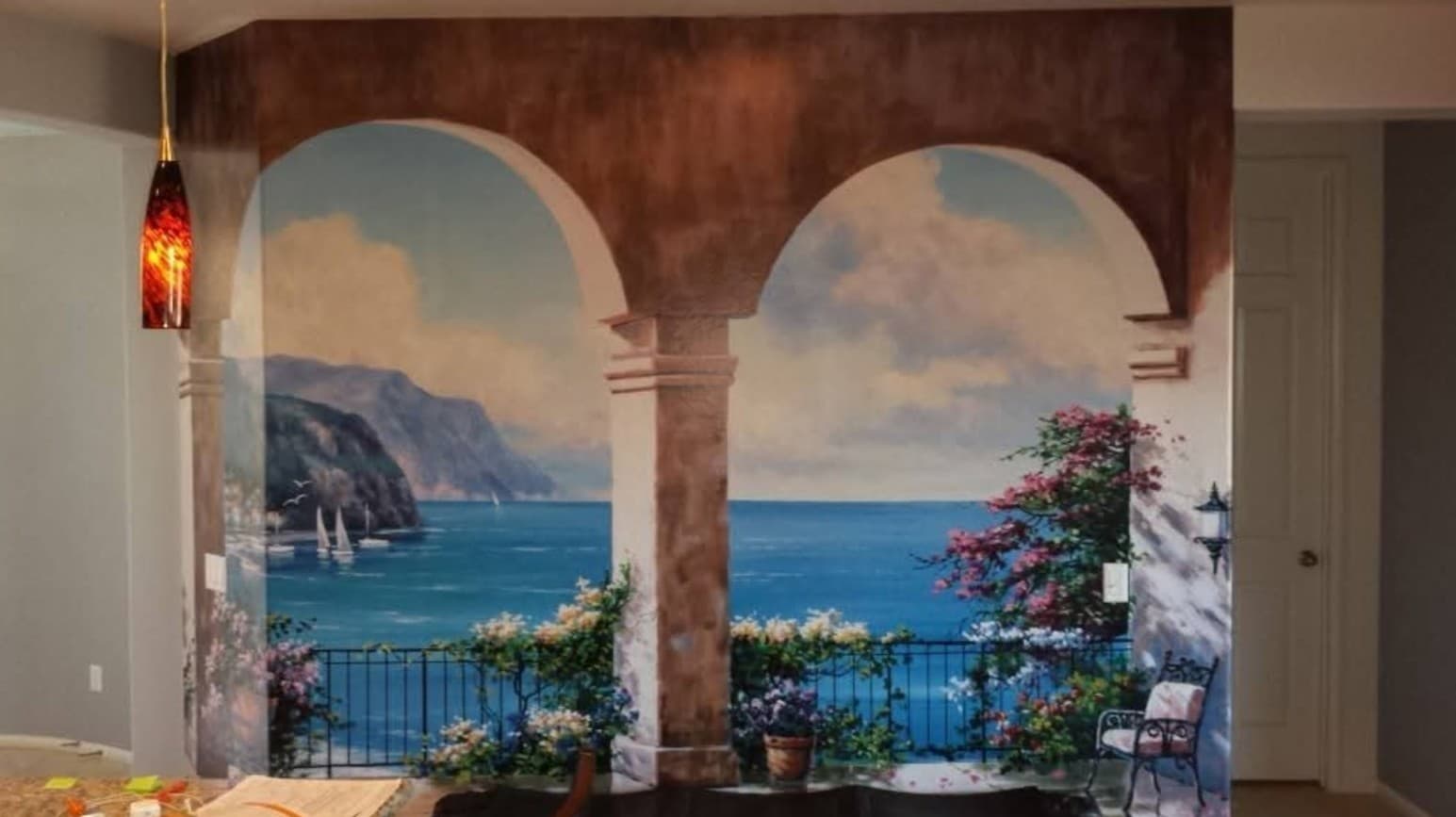 Large-scale Mediterranean coastal arch mural wallpaper installation in a residential home in Southern California