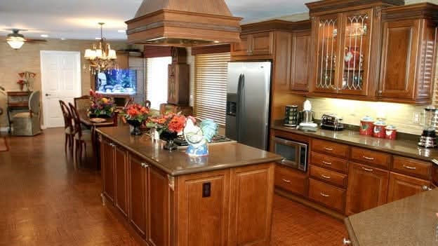 Open kitchen with grasscloth wallpaper and custom wood cabinetry featured on Extreme Makeover Home Edition TV show